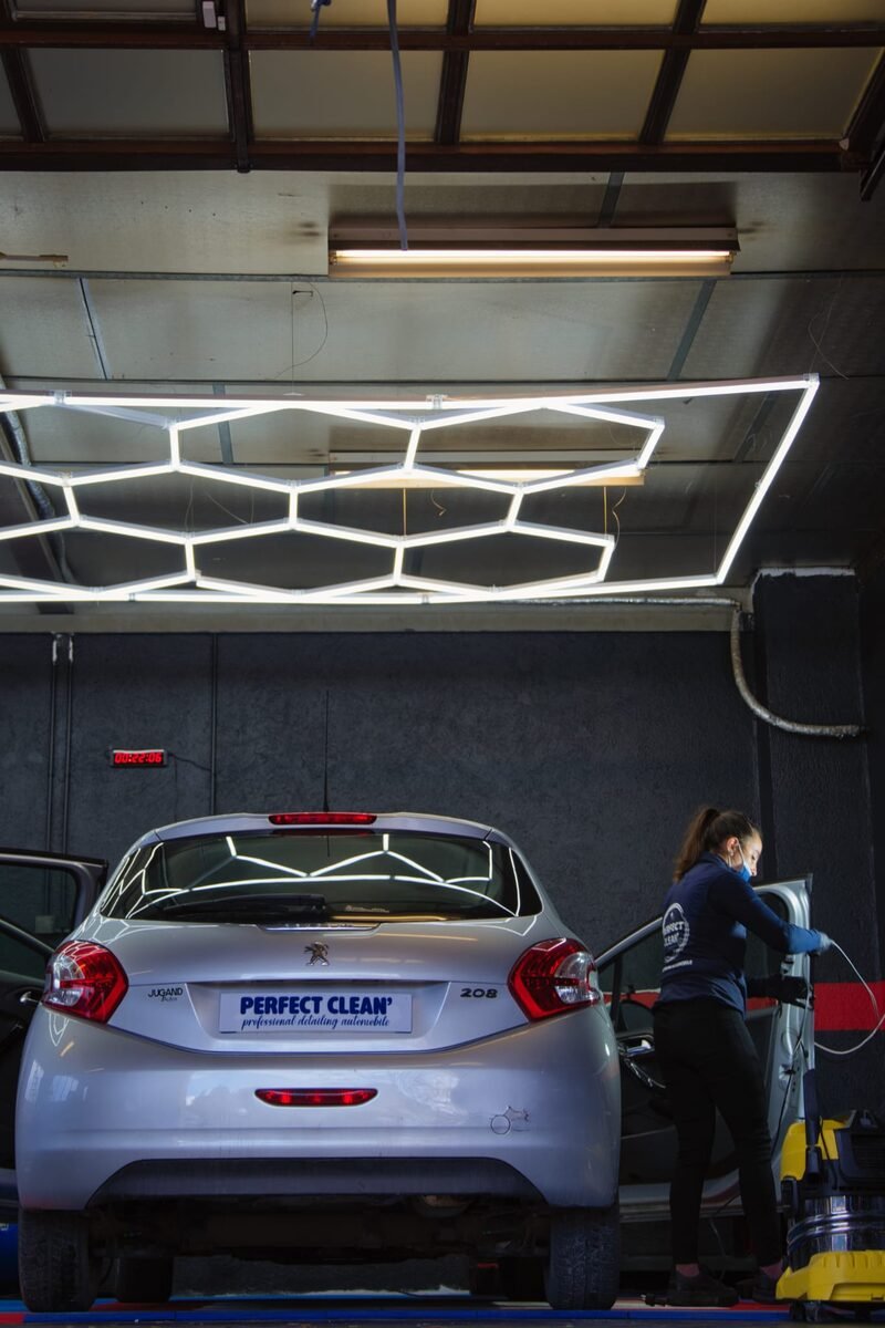 Vue verticale de la baie d'atelier Perfect Clean 74 sous la rampe hexagonale LED, détailleuse en intervention